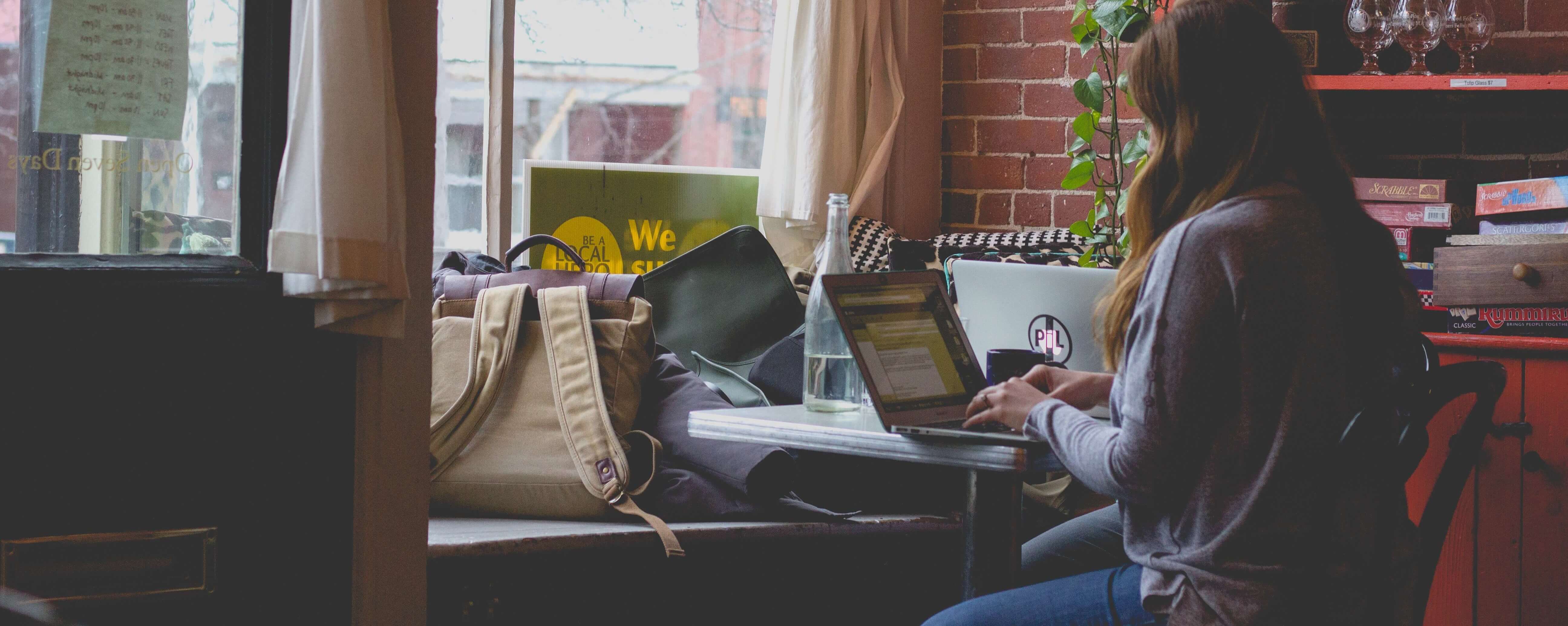 a girl using her computer by the window | Guild Education